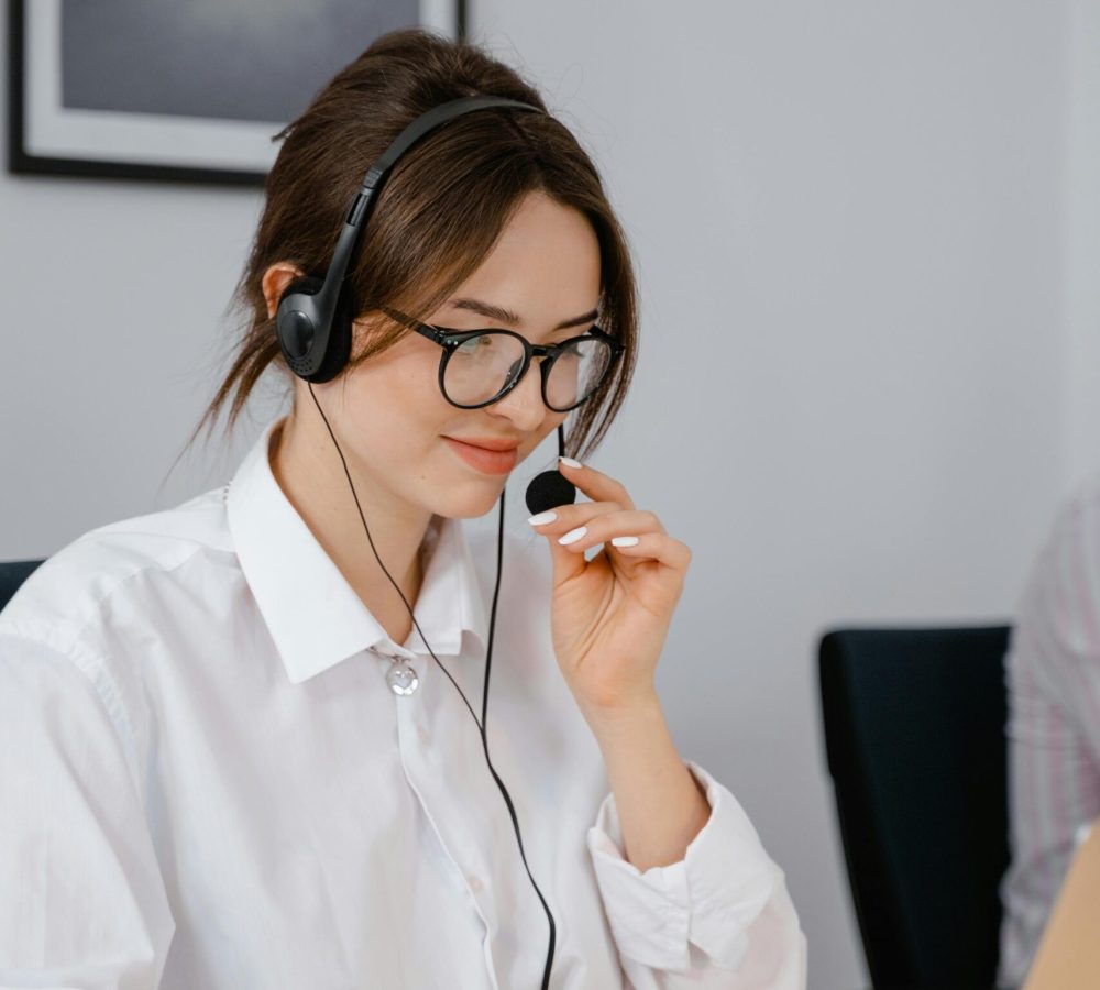 Professional woman using headset for customer service in office setting.